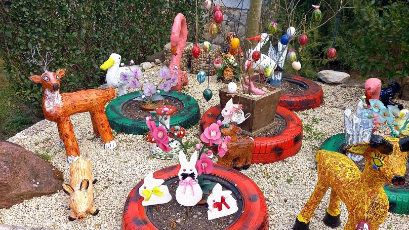 Rongyból készült váza és cement flamingó egy örvényesi kertben